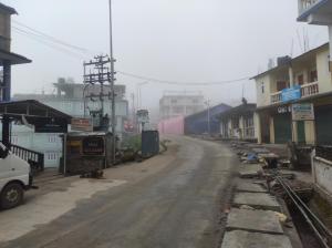 eine leere Straße in einer Stadt mit Zug in der Unterkunft Hotel Amala in Tawang