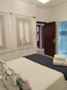 a bedroom with a large white bed with pillows at Hostel Mayflowers in Córdoba