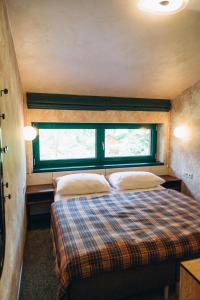 uma cama num pequeno quarto com uma janela em Hotel Vodník em Vimperk