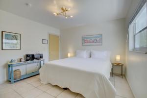 um quarto branco com uma cama grande e um micro-ondas em LoKal Rental Tropical Florida destination em Fort Lauderdale