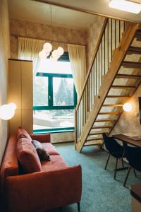 - un salon avec un canapé et un escalier dans l'établissement Hotel Vodník, à Vimperk