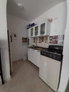 a kitchen with white cabinets and a stove at Alojamiento Ricaurte Piso 6 in Ricaurte