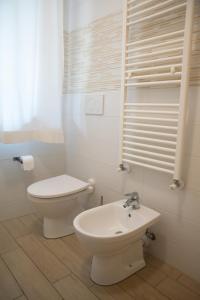 a white bathroom with a toilet and a sink at Cimoneight in Varese