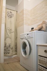 eine Waschmaschine in einer Waschküche mit Duschvorhang in der Unterkunft Cimoneight in Varese
