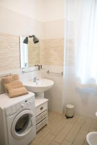 uma casa de banho com uma máquina de lavar roupa e um lavatório em Cimoneight em Varese