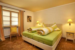 a bedroom with a bed with yellow and white pillows at Gästehaus am Brunnen in Bad Hindelang