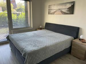 a bedroom with a bed and a large window at Garden Apartman Radnica in Košice