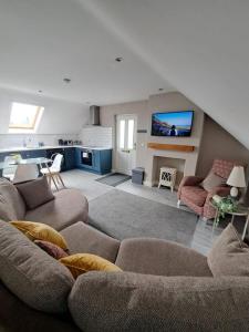 a living room with a couch and a tv at Lakeland Lodge in Derrylin
