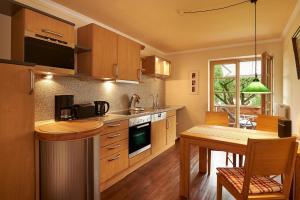 a kitchen with wooden cabinets and a table and a dining room at Gästehaus am Brunnen in Bad Hindelang