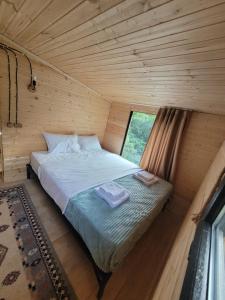 1 dormitorio con 1 cama en una cabaña de madera en Guest cottage - Nanka's house en Batumi