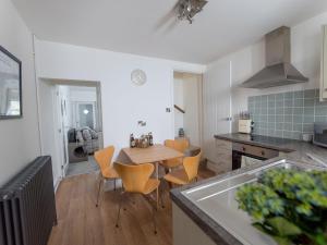 a kitchen and dining room with a table and chairs at Park Grange Cottage in Skipton
