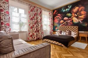 a bedroom with a bed and a painting on the wall at Mikołajska 5 Apartments in Krakow