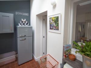 a kitchen with a refrigerator in the corner of a room at Park Grange Cottage in Skipton