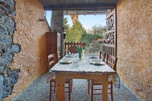 una mesa en una habitación al aire libre con una pared de piedra en Cascina Taronico, en Bellagio