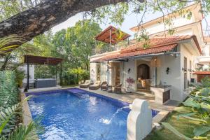 a swimming pool in the backyard of a house at LohonoStays Colina Villa E in Vagator