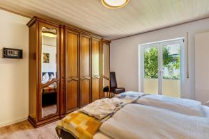 ein Schlafzimmer mit einem großen Bett und einem Holzschrank in der Unterkunft Ferienwohnung Kuckucksnest in Lahr