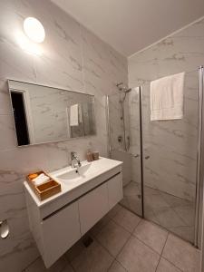 a white bathroom with a sink and a shower at Lincoln Design Apartments in Jerusalem