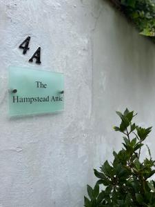 una señal en un lado de un edificio blanco en Studio flat in the heart of Hampstead, London, en Londres