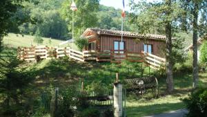 une cabane en rondins avec un banc devant elle dans l'établissement Gîte la Lanterne transition écologique avec borne de recharge 7kw Site sous vidéo protection, à Nalzen