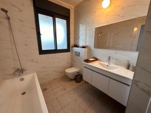 a bathroom with a sink and a toilet and a window at Lincoln Design Apartments in Jerusalem