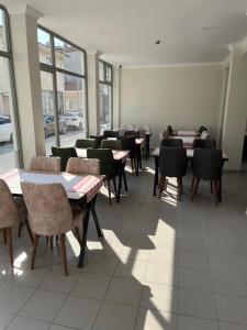 ein Esszimmer mit Tischen, Stühlen und Fenstern in der Unterkunft Maritsa Hotel in Edirne