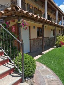 ein Gebäude mit einer weißen Tür und ein paar Blumen in der Unterkunft Hotel Posada El Camino in Chignahuapan