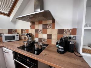 a kitchen with a stove and a microwave at Studio flat in the heart of Hampstead, London in London