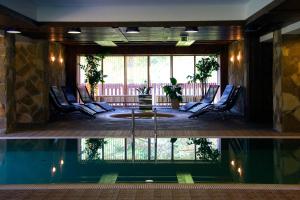 a pool with chairs and a fountain in a building at Country hotel Gladenkaya in Sayanogorsk
