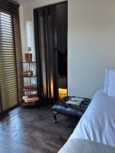 um quarto com uma cama e uma cadeira de couro em Luxurious cabin with desk & mini library em Parkstone
