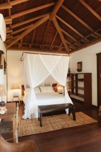 um quarto com uma cama e uma rede mosquiteira em Pousada Casa Mar pé na areia em Caraíva