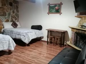 Zimmer mit einem Bett, einem Tisch und einem Kamin in der Unterkunft Hotel Posada El Camino in Chignahuapan