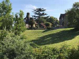 a house on a hill with a large grass field at Mulberry Cottage in Cheltenham