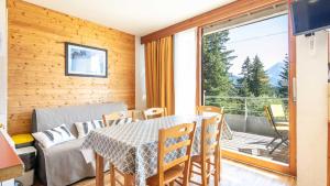 ein Esszimmer mit einem Tisch und einem Balkon in der Unterkunft V du Bachat B01 - Appt lumineux 6 pers in Chamrousse