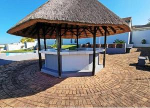 un padiglione con ombrellone di paglia su un patio in mattoni di Nomads Nook 7 Sea view 6 Sleeper a Margate