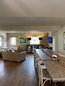 a living room with a large wooden table and chairs at Mulberry Cottage in Cheltenham