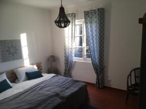 een slaapkamer met een bed en een raam bij Mon Gîte en Provence in Salernes