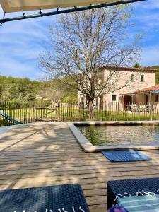 een houten terras met een zwembad voor een huis bij Mon Gîte en Provence in Salernes