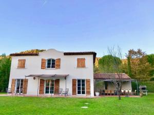 een groot wit huis met een tuin met stoelen bij Mon Gîte en Provence in Salernes
