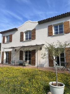 een wit huis met houten luiken bij Mon Gîte en Provence in Salernes