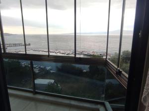 una ventana grande con vistas al océano. en Clifftop Bliss: Beach View, 2BR en Mudanya