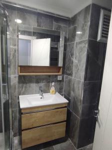 a small bathroom with a sink and a mirror at Clifftop Bliss: Beach View, 2BR in Mudanya