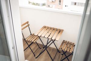 2 sillas de madera sentadas junto a un mostrador en ALFALFA A Apartments, en Madrid