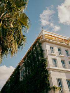 um edifício alto com uma palmeira em frente em Rooms Hotel Batumi em Batumi