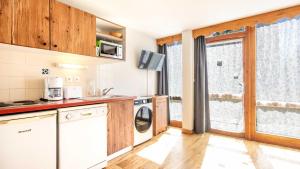 a kitchen with a washer and dryer at V du Bachat A04 ASTERS - Appt spacieux 4 pers in Chamrousse