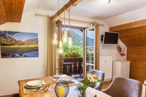 ein Esszimmer mit einem Tisch, Stühlen und einem Fenster in der Unterkunft Ferienwohnung Reschberg in Farchant