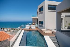 a villa with a swimming pool and a view of the ocean at Alectrona Living Crete, Olīvea Luxury Apartment in Plataniás