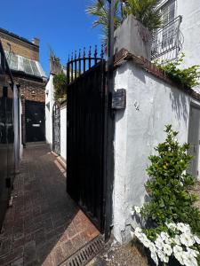 ein schwarzes Tor an der Seite eines weißen Gebäudes in der Unterkunft Studio flat in the heart of Hampstead, London in London