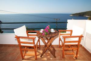 a table and chairs on a balcony with the ocean at Kalithea Studios in Stafylos