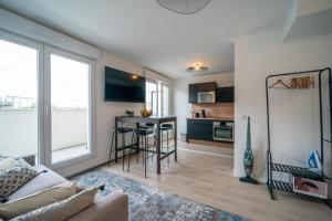 a living room with a couch and a table at Carré d'As - Appartement de standing in Le Bourget