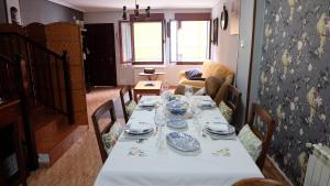 - une table avec des assiettes et de la vaisselle dans le salon dans l'établissement Playa de la palmera, à Candás